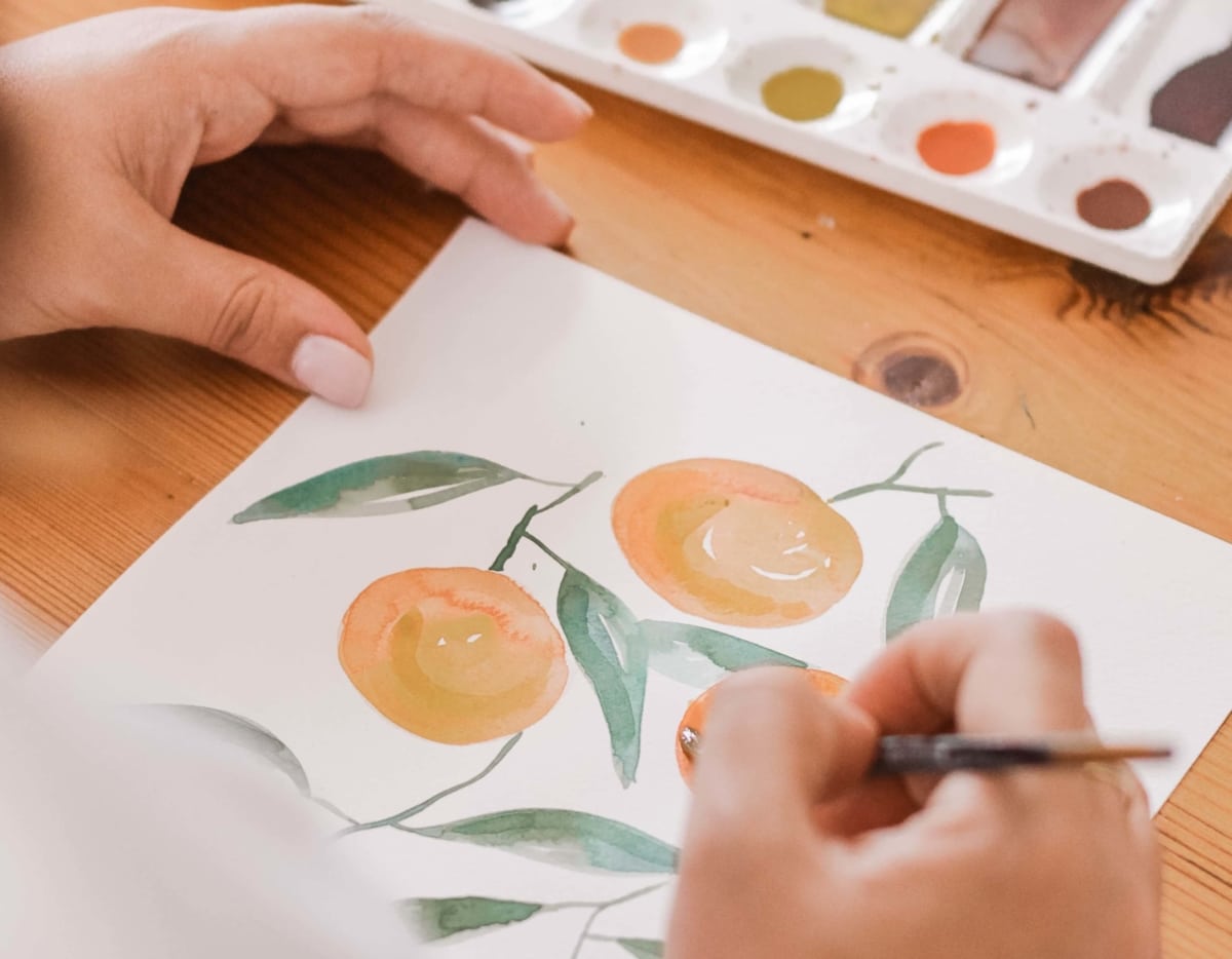 photo d'un dessin en aquarelle d'oranges peint par une personne avec un pnceau